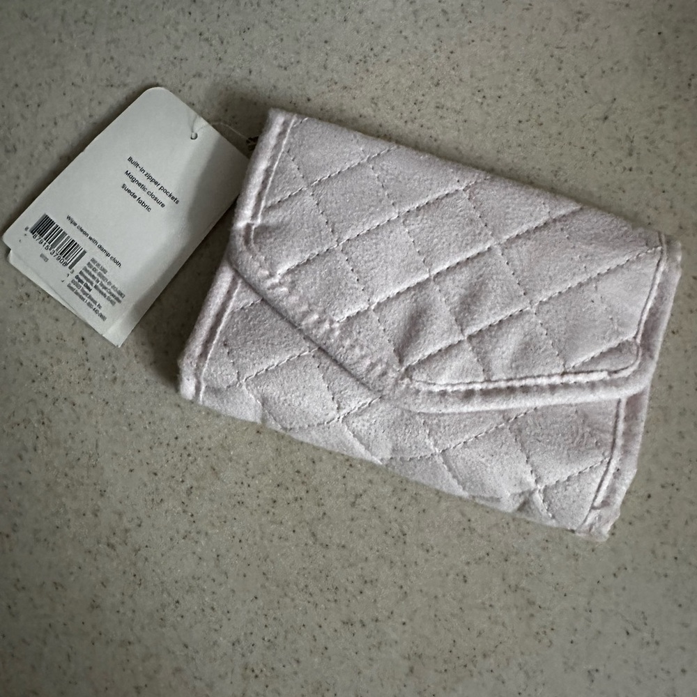 travel jewelry organizer roll in a light pink fabric material